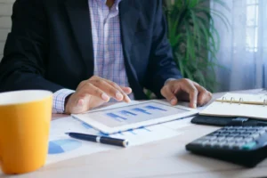 Podnikateľ pracujúci s tabletom a analyzujúci finančné grafy v kancelárii.